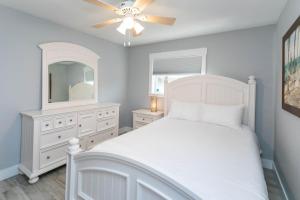 a bedroom with a white bed and a ceiling fan at Captains Quarters Island location Hot tub One Level in Saint Augustine