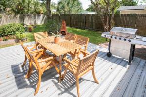 a wooden table and chairs sitting on a deck with a grill at Captains Quarters Island location Hot tub One Level in Saint Augustine