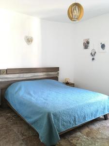 a bed in a room with a blue blanket at 270° in Hydra