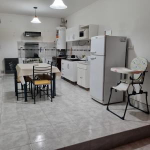 a kitchen with a table and chairs and a refrigerator at La Posada del Turista in Trelew