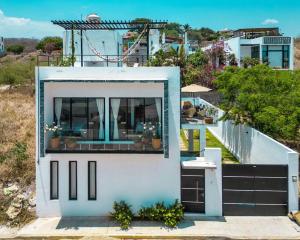 a house with a large window on top of it at Casa Tres Iguanas, La Punta in Puerto Escondido