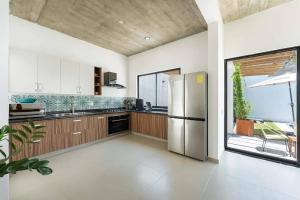 a kitchen with a stainless steel refrigerator and a window at Casa Tres Iguanas, La Punta in Puerto Escondido