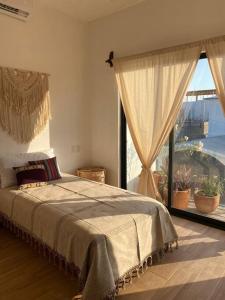 a bedroom with a bed and a large window at Casa Tres Iguanas, La Punta in Puerto Escondido +30 photos