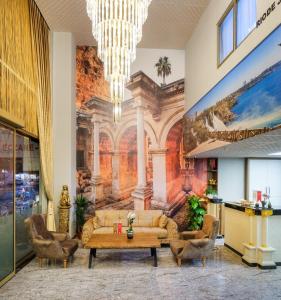 vestíbulo con sofá, sillas y mural en Grand Gulluk Hotel & Spa en Antalya