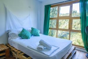 a bed in a room with a large window at Hostal Mama Tayrona in Santa Marta