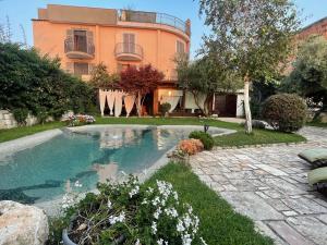a house with a swimming pool in the yard at DOMUS PARVA - Villa con bio-piscina, spa privata e appartamenti panoramici in Bacoli