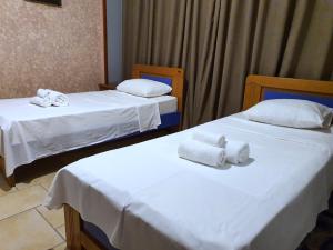 two beds in a hotel room with towels on them at Jessie's apartments in Durrës