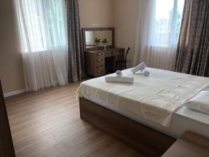 a bedroom with a bed and a dresser and a mirror at Guest House Bagrationi in Batumi