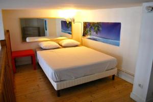 - une chambre avec 2 lits et un miroir dans l'établissement L'appartement du Parc, à Lyon