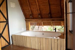 a large bath tub in a room with a window at Glamping con jacuzzi cerca a Medellin in Guarne