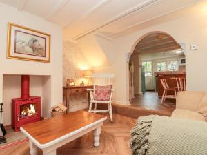 a living room with a fireplace and a table at Red Grouse Cottage in Guisborough