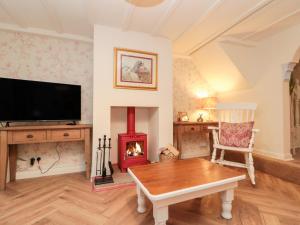 a living room with a fireplace and a tv at Red Grouse Cottage in Guisborough