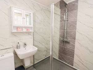 ein weißes Badezimmer mit Dusche und Waschbecken in der Unterkunft Red Grouse Cottage in Guisborough + 34 Fotos