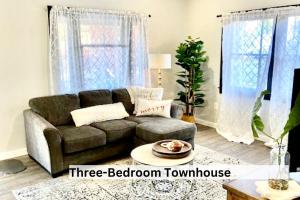 ein Wohnzimmer mit einem braunen Sofa und einem Tisch in der Unterkunft Downtown Boho Revival Home PNW in Albany