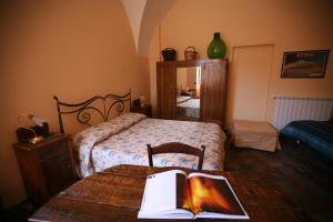 a bedroom with a bed and a table with a book on it at La Casa Dei Cestai in Linguaglossa