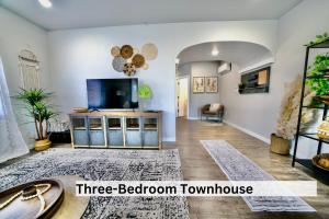 a living room with a flat screen tv and a three bedroom town house at Downtown Boho Revival Home PNW in Albany