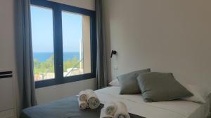 a bedroom with a bed with towels on it with a window at Casa di Pino in Cefalù