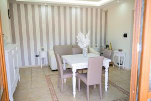 una sala da pranzo con tavolo e sedie bianchi di Venere apartement house a Montalto Uffugo