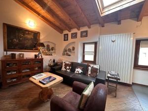 a living room with a couch and a table at Nido Mountain Apartment in Castione della Presolana