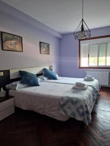 a bedroom with a large bed with blue walls at O Parrandeiro in Padrón