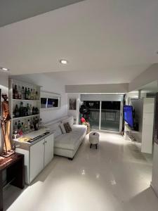 a living room with a white couch and a kitchen at Apart Recoleta con jacuzzi y balcón con parrilla propio in Buenos Aires