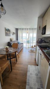 Una cocina y una sala de estar con un sofá y una mesa. en Saint-Raphael- Vue mer et Massif de l'Esterel, en Saint-Raphaël
