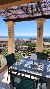 Una mesa y sillas en un patio con vista. en Saint-Raphael- Vue mer et Massif de l'Esterel, en Saint-Raphaël