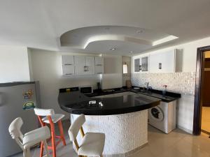 a kitchen with a black counter and white cabinets at Alamein apartments prime residence in El Alamein