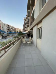 a balcony of a building with a table and chairs at Alamein apartments prime residence in El Alamein