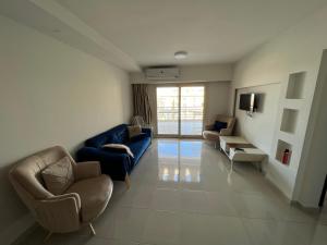 a living room with a blue couch and chairs at Alamein apartments prime residence in El Alamein