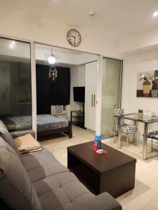 - un salon avec un canapé et un réveil sur le mur dans l'établissement Azure Urban Resort Residences, à Manille