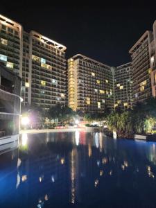 - une vue sur un hôtel la nuit avec une rivière dans l'établissement Azure Urban Resort Residences, à Manille