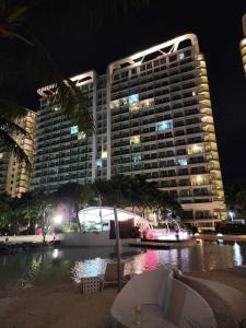un grand bâtiment en face d'une piscine la nuit dans l'établissement Azure Urban Resort Residences, à Manille