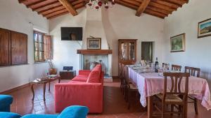 uma sala de jantar com uma mesa longa e cadeiras vermelhas em Mulinaccio di Badia em Gaiole in Chianti