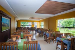 un ristorante con tavoli e sedie in legno in una stanza di Hotel Crown Himalayas a Pokhara