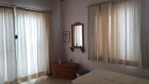 um quarto com uma cama e 2 janelas grandes em Villa Jardines la Quinta em El Paso