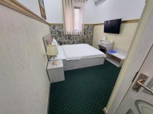 um quarto de hotel com uma cama e uma televisão em SEMURG HOTEL em Tashkent