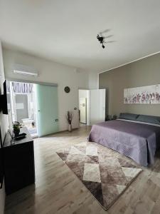 a bedroom with a purple bed and a rug at Essential House in Brindisi
