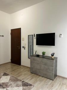 a living room with a flat screen tv on a wall at Essential House in Brindisi