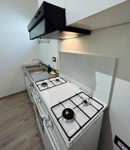 a kitchen with a stove top oven in a kitchen at Essential House in Brindisi