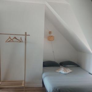 a bedroom with a bed in a attic at Gîte le Rouge Gorge de Brocéliande in Beignon