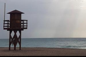 una torre salvavidas en la playa cerca del océano en Apartamento junto al mar con WiFi y piscina, en Sagunto