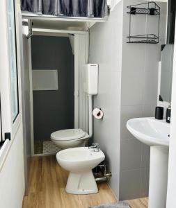 a bathroom with a toilet and a sink at Essential House in Brindisi