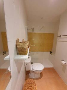 y baño con aseo blanco y ducha. en Apartamento junto al mar con WiFi y piscina, en Sagunto