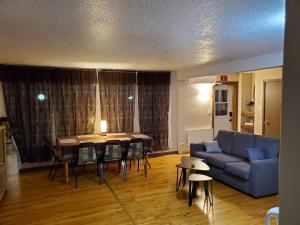 ein Wohnzimmer mit einem blauen Sofa und einem Tisch in der Unterkunft Le1226 Apartment in Edmundston
