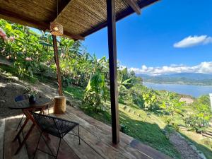 d'une terrasse avec une table et des chaises et une vue sur l'eau. dans l'établissement Tierra Alta, Refugio de Montaña, Sauce, à Sauce