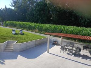 a patio with a table and chairs next to a field at Casa da Americana I in Boqueijón