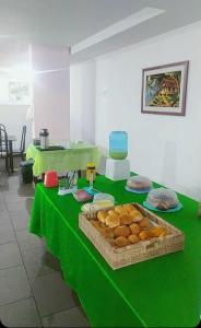 a table with a green table cloth and a table with bread at Hotel Estação Norte - Fácil acesso ao Imbel e o distrito industrial e colégio Militar - By Up Hotel in Juiz de Fora