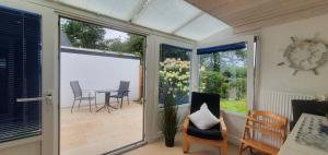 a screened in porch with a table and chairs at Ferienhaus Frische Brise direkt am Nordsee Deich in Spieka-Neufeld