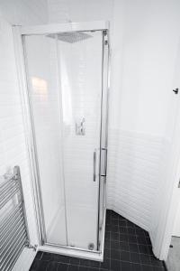a shower with a glass door in a bathroom at Charming 2 BR, 5 min to metro, easy central access in London